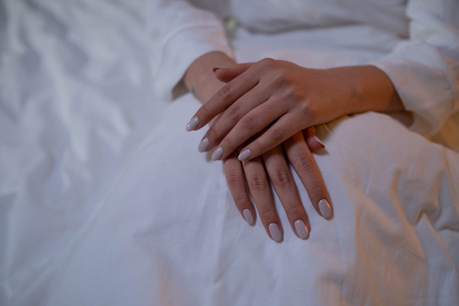 Short almond-shaped nude press-on nails on a hand — a category photo, not this product